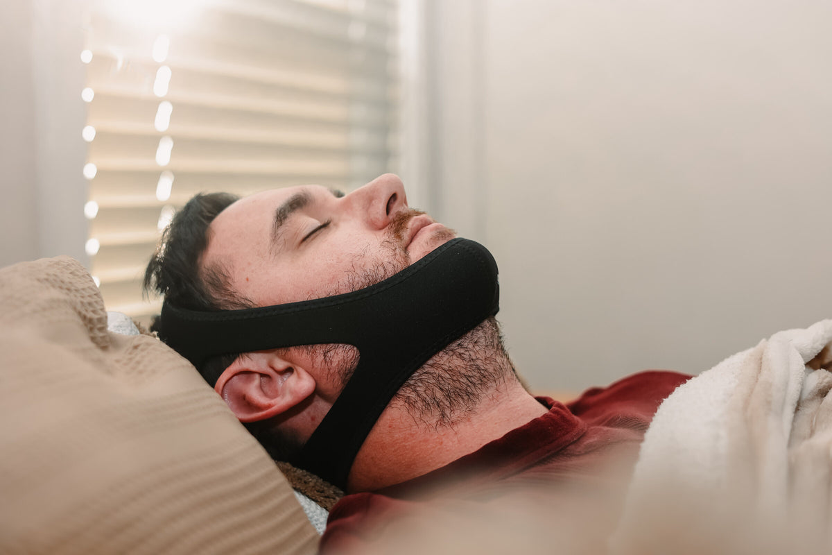 Model wearing Certified Sleepers chin strap while resting